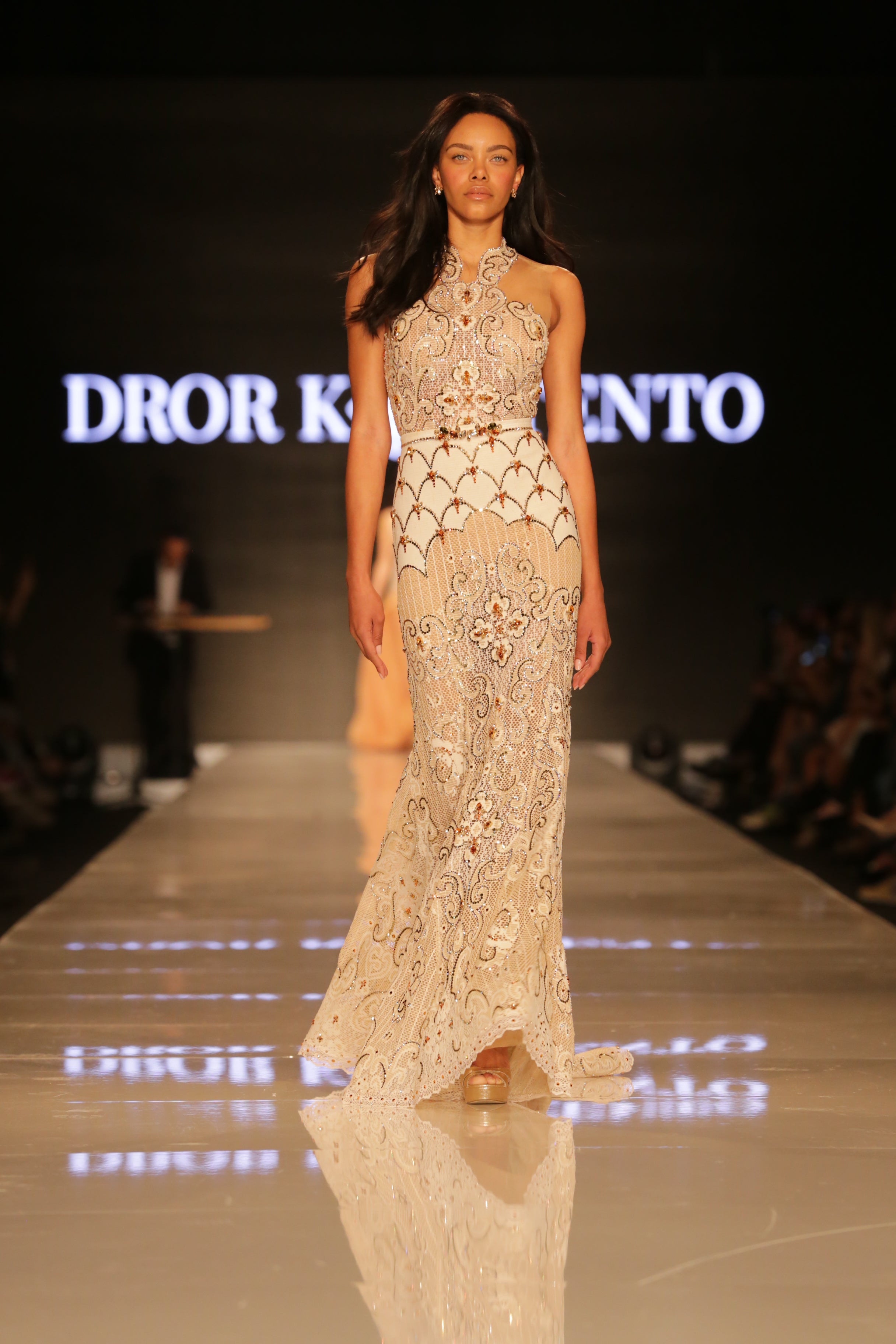 דוגמנית לובשת שמלת תחרה משובצת אבני קריסטל 