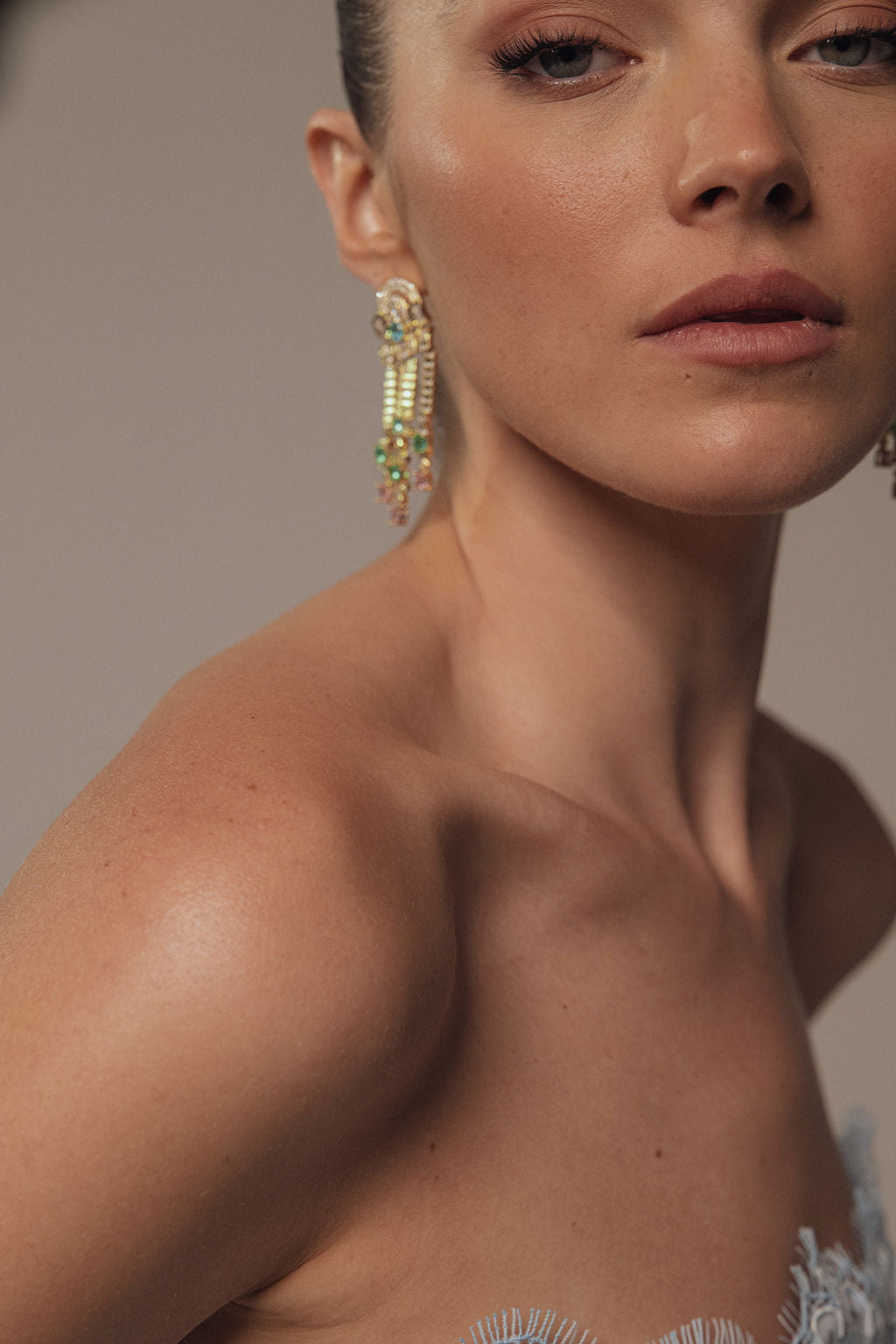 תקריב של אישה העונדת את עגילי Tara מקולקציית Evening 2026, עם חרוזים מעוטרים, בשילוב עם חולצה ללא כתפיות ואיפור טבעי.